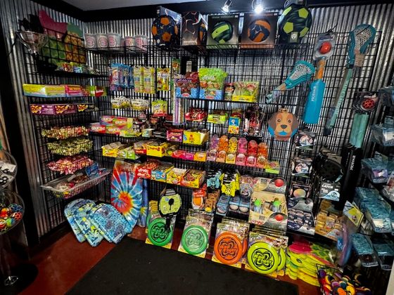 A back room of candy shelves, frisbees, water volleyballs and pool toys