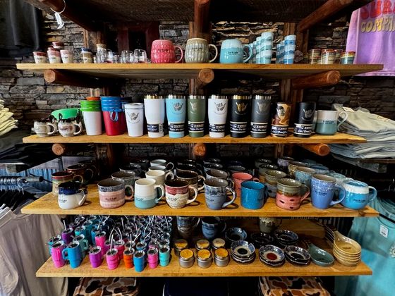 Shelves of insulated tumblers, ceramic mugs, shot glasses and mini tumbler keychains
